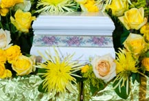 A cremation urn surrounded by yellow flowers.